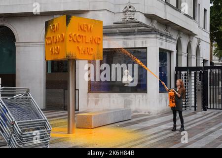 Ein „Just Stop Oil“-Spray malt ein Schild vor dem New Scotland Yard in London. Bilddatum: Freitag, 14. Oktober 2022. Stockfoto
