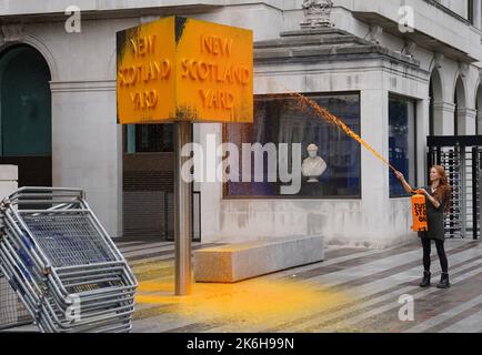 Ein „Just Stop Oil“-Spray malt ein Schild vor dem New Scotland Yard in London. Bilddatum: Freitag, 14. Oktober 2022. Stockfoto