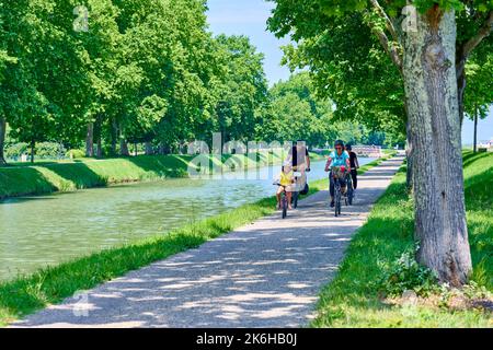 Radtour in der Umgebung der Montech Wasserhang, entlang des Canal lateral a la Garonne. Familie Radfahren zusammen auf dem Schleppturm, im Schatten o Stockfoto