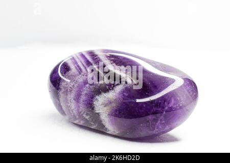 Echtes gestrommenes purpurnes und weißes Chevron-Amethyst konzentrierte sich auf weißes Oberflächenmakro Stockfoto