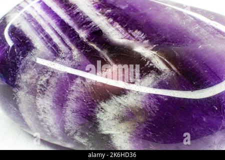 Echtes gestrommenes purpurnes und weißes Chevron-Amethyst konzentrierte sich auf weißes Oberflächenmakro Stockfoto