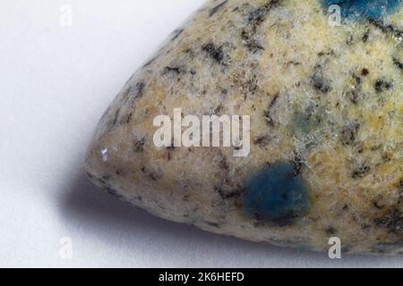 K2 Jaspis, K2 Granit, Regentropfen-Azurit-Makrofotografie auf weißer Oberfläche. Makrofoto von Stein auf weißem Hintergrund. Stockfoto