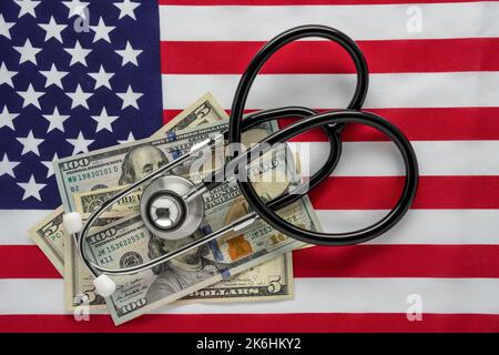 Die Vereinigten Staaten Flagge mit 100 und 5 und 1-Dollar-Scheine und ein Stesteskop für Konzepte der Gesundheit der Wirtschaft und Kosten der Gesundheitsversorgung Stockfoto