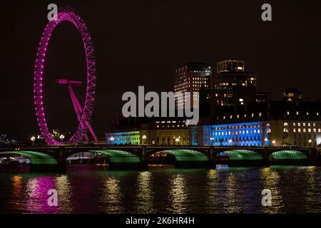 Westminster, London, Großbritannien. 12.. Oktober 2022. Das mit pinkfarbenen Lichtern beleuchtete Londoner Auge reflektiert auf die Themse in Westminster, London. Die County Hall ist auch mit LGBT-Farben des Regenbogens beleuchtet. Kredit: Maureen McLean Stockfoto