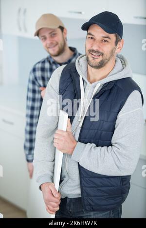 Zwei movers in Uniform Transport Tabelle in der Wohnung Stockfoto