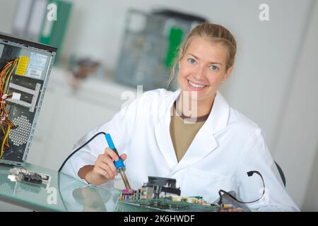 Technikerin, die elektronische Bauteile lötet Stockfoto