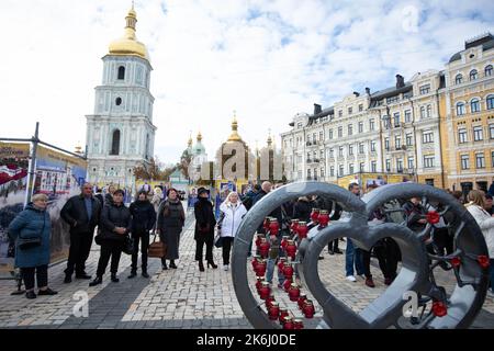 Die Menschen besuchen die Straßenausstellung „Asow-Regiment - Engel von Mariupol“, die den Verteidigern der Einheit „Asow“ der Nationalgarde der Ukraine gewidmet ist, die bei der Verteidigung von Mariupol vor den russischen Invasoren in Kiew ums Leben gekommen sind. Russische Truppen sind am 24. Februar 2022 in die Ukraine eingedrungen und haben einen Konflikt ausgelöst, der Zerstörung und eine humanitäre Krise provoziert hat. Stockfoto