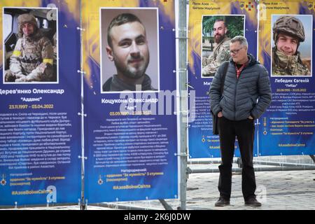Ein Mann besucht die Straßenausstellung „Asow-Regiment - Engel von Mariupol“, die den Verteidigern der Einheit „Asow“ der Nationalgarde der Ukraine gewidmet ist, die bei der Verteidigung von Mariupol vor den russischen Invasoren in Kiew ums Leben gekommen sind. Russische Truppen sind am 24. Februar 2022 in die Ukraine eingedrungen und haben einen Konflikt ausgelöst, der Zerstörung und eine humanitäre Krise provoziert hat. Stockfoto