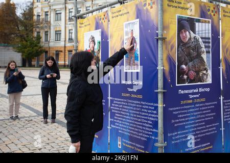 Kiew, Ukraine. 14. Oktober 2022. Eine Frau reagiert emotional auf die Straßenausstellung „Asow-Regiment - Engel von Mariupol“, die den Verteidigern der Einheit „Asow“ der Nationalgarde der Ukraine gewidmet ist, die bei der Verteidigung von Mariupol vor den russischen Eindringlingen in Kiew starb. Russische Truppen sind am 24. Februar 2022 in die Ukraine eingedrungen und haben einen Konflikt ausgelöst, der Zerstörung und eine humanitäre Krise provoziert hat. (Foto von Oleksii Chumachenko/SOPA Images/Sipa USA) Quelle: SIPA USA/Alamy Live News Stockfoto