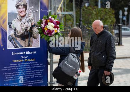 Ein Mädchen legt Blumen in die Straßenausstellung „Asow-Regiment - Engel von Mariupol“, die den Verteidigern der Einheit „Asow“ der Nationalgarde der Ukraine gewidmet ist, die bei der Verteidigung von Mariupol vor den russischen Invasoren in Kiew ums Leben gekommen sind. Russische Truppen sind am 24. Februar 2022 in die Ukraine eingedrungen und haben einen Konflikt ausgelöst, der Zerstörung und eine humanitäre Krise provoziert hat. (Foto von Oleksii Chumachenko / SOPA Images/Sipa USA) Stockfoto