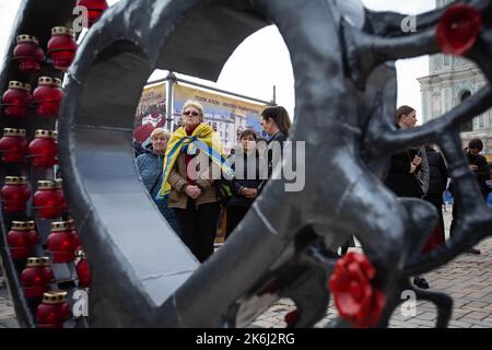 Kiew, Ukraine. 14. Oktober 2022. Die Menschen besuchen die Straßenausstellung „Asow-Regiment - Engel von Mariupol“, die den Verteidigern der Einheit „Asow“ der Nationalgarde der Ukraine gewidmet ist, die bei der Verteidigung von Mariupol vor den russischen Invasoren in Kiew ums Leben gekommen sind. Russische Truppen sind am 24. Februar 2022 in die Ukraine eingedrungen und haben einen Konflikt ausgelöst, der Zerstörung und eine humanitäre Krise provoziert hat. (Bild: © Oleksii Chumachenko/SOPA Images via ZUMA Press Wire) Stockfoto