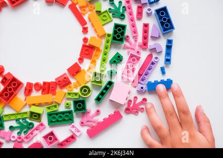 Kleines Kind spielt mit bunten Lernspielzeug auf weißem Hintergrund. Pädagogisches Spielzeug für kleine Kinder. Frühkindliche Entwicklung. Zu Hause Stockfoto