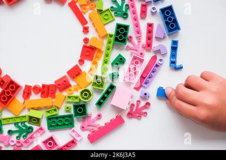 Kleines Kind spielt mit bunten Lernspielzeug auf weißem Hintergrund. Pädagogisches Spielzeug für kleine Kinder. Frühkindliche Entwicklung. Zu Hause Stockfoto