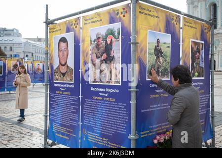 Kiew, Ukraine. 14. Oktober 2022. Eine Frau reagiert emotional auf die Straßenausstellung „Asow-Regiment - Engel von Mariupol“, die den Verteidigern der Einheit „Asow“ der Nationalgarde der Ukraine gewidmet ist, die bei der Verteidigung von Mariupol vor den russischen Eindringlingen in Kiew starb. Russische Truppen sind am 24. Februar 2022 in die Ukraine eingedrungen und haben einen Konflikt ausgelöst, der Zerstörung und eine humanitäre Krise provoziert hat. (Bild: © Oleksii Chumachenko/SOPA Images via ZUMA Press Wire) Stockfoto