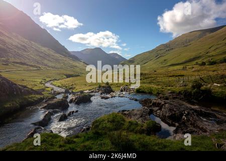 Abgelegene Schönheit während der Fahrt durch den Sheeffry Pass von Liscarny nach Doolough, wo sich der Glenummera River zwischen den Sheeffry Hills schlängelt Stockfoto