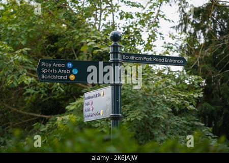 Boultham Park, Lincoln, Lincolnshire, Bereich, Parkbank, Freiflächen, Grün, Bäume, schattig, Abdeckung, Waldgebiet, reich verzierte Wegweiser, Fingerpost-Café Stockfoto