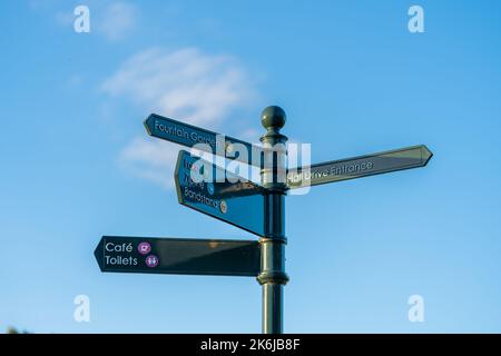 Boultham Park, Lincoln, Lincolnshire, Bereich, Parkbank, Freiflächen, Grün, Bäume, schattig, Abdeckung, Waldgebiet, reich verzierte Wegweiser, Fingerpost-Café Stockfoto