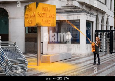 Ein „Just Stop Oil“-Spray malt ein Schild vor dem New Scotland Yard in London. Bilddatum: Freitag, 14. Oktober 2022. Stockfoto
