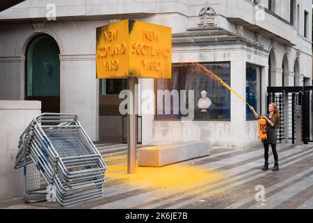 Ein „Just Stop Oil“-Spray malt ein Schild vor dem New Scotland Yard in London. Bilddatum: Freitag, 14. Oktober 2022. Stockfoto