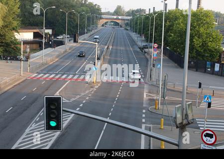 Warschau, Polen - Blick auf eine Autobahn mit Ampeln, Straßenmarkierungen und einer Steinbrücke im Hintergrund. Stockfoto