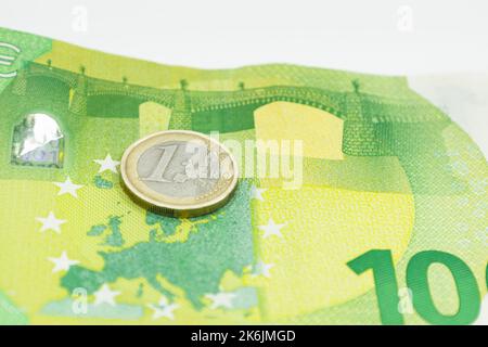Eine Euro-Münze auf der 100-Euro-Banknote Stockfoto
