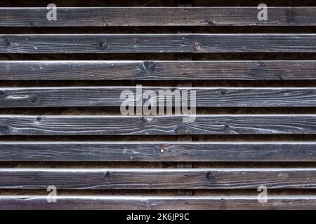 Fragment einer Wand aus alten verwitterten Holzlatten. Zur Verwendung als abstrakter Hintergrund. Stockfoto