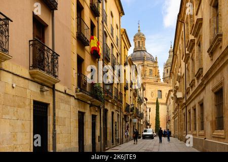Enge gepflasterte Straße in Salamanca vor dem Hintergrund der barocken Kuppel von La Clerecia Stockfoto