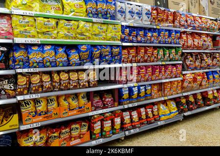 Regale mit einer Auswahl an knusprigen Packungen in einem Tesco Supermarkt, London, England, Großbritannien Stockfoto