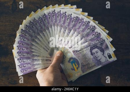 Ein Mann mit britischen 20-Pfund-Noten Stockfoto