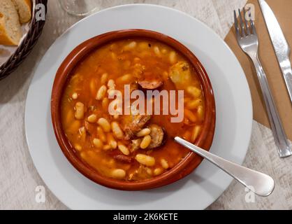 Fabada asturiana serviert in braunen Teller Stockfoto