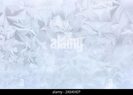 Frostige Muster auf Glas, silberner Weihnachtshintergrund Stockfoto