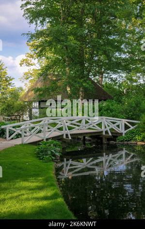 BILLUM, DÄNEMARK - 28/JUNI/2010: Landschaftsansicht des alten klassischen traditionellen dänischen Landhauses in der Nähe des Flusses und der Brücke Stockfoto