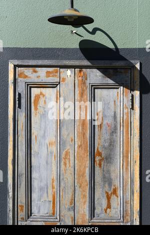 Industrieller Hintergrund von abgebrochene Farbe an einer alten Tür Stockfoto