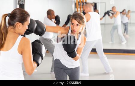 Aktive junge Frau übt Schläge Stockfoto