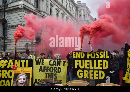 London, Großbritannien. 14. Oktober 2022. Während der Demonstration vor der Downing Street halten Demonstranten Rauchfackeln und Banner gegen fossile Brennstoffe auf. Die Demonstranten des Extinction Rebellion versammelten sich in Westminster und forderten Maßnahmen gegen die Klimakrise und explodierende Energiekosten. Kredit: SOPA Images Limited/Alamy Live Nachrichten Stockfoto