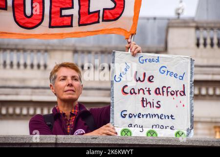 London, Großbritannien. 14. Oktober 2022. Ein Protestler hält ein Plakat mit der Aufschrift „Wir können uns diese Regierung nicht leisten“ während der Demonstration auf dem Trafalgar Square. Die Demonstranten des Extinction Rebellion versammelten sich in Westminster und forderten Maßnahmen gegen die Klimakrise und explodierende Energiekosten. Kredit: SOPA Images Limited/Alamy Live Nachrichten Stockfoto