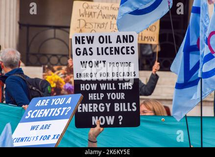 London, Großbritannien. 14. Oktober 2022. Ein Protestler hält während der Demonstration auf dem Trafalgar Square ein Plakat, auf dem steht, dass neue Öl- und Gaslizenzen nicht helfen werden, die Energiekostenkrise zu lösen. Die Demonstranten des Extinction Rebellion versammelten sich in Westminster und forderten Maßnahmen gegen die Klimakrise und explodierende Energiekosten. (Foto: Vuk Valcic/SOPA Images/Sipa USA) Quelle: SIPA USA/Alamy Live News Stockfoto