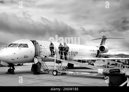 Passengerss besteigen ein von SkyWest betriebenes American Eagle Bombardier-Flugzeug am Santa Fe Municipal Airport in Santa Fe, New Mexico. Stockfoto