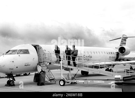 Passengerss besteigen ein von SkyWest betriebenes American Eagle Bombardier-Flugzeug am Santa Fe Municipal Airport in Santa Fe, New Mexico. Stockfoto