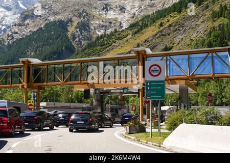 Autos stehen im Sommer am Eingang des Mont-Blanc-Tunnels an der italienischen Grenze, Courmayeur, Aosta-Tal, Italien Stockfoto