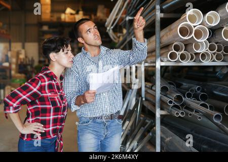 Mann und Frau führen gemeinsam die Buchhaltung und Inventur in einem Baustofflager durch Stockfoto