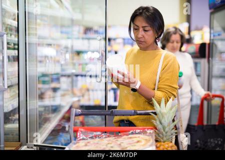 Weibliche Shopper wählt Milchprodukte im Supermarkt Stockfoto