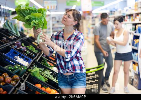 Frau, die Salat im Supermarkt wählt Stockfoto