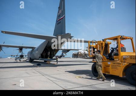 USA Der Senior Airman der Luftwaffe, Levi Valentine, Ladermeister der Luftlift Squadron 37., leitet eine Palette, die auf einen C-130J Super Hercules im Camp Lemonnier, Dschibuti, geladen wird, 5. Oktober 2022. Die C-130H Super Hercules der Expeditionary Airlift Squadron 75. wurde aufgrund einer technischen Anordnung zur Einhaltung der Zeitvorgaben, die am 27. September 2022 erteilt wurde, geerdet. Die EAS-Mission von 75. als einziges Airlift Squadron in Afrika wurde nicht gestoppt. Andere C-130J und H Modell Super Hercules sind gekommen, um die Mission fortzusetzen. (USA Foto der Luftwaffe von Staff Sgt. Branden Rae) Stockfoto