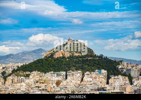 Lycabettus Hill unter weißen Wolken von der Akropolis aus gesehen Stockfoto