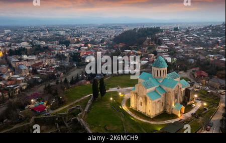 Blick von der Drohne auf die beleuchtete Kathedrale von Dormition in Kutaisi am Abend Stockfoto