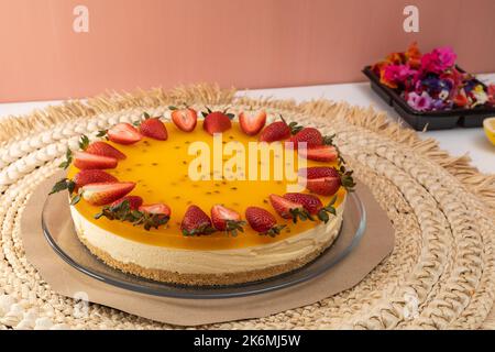 Desserts für Geburtstagsfeier, Kuchen mit kreisförmiger Form mit Erdbeeren verziert, Lebensmittel mit tropischen Früchten im Studio, Tapete Stockfoto