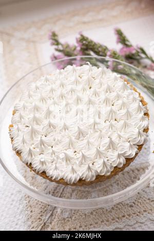 Köstliche Kuchen mit Gebäck-Creme, neben einer natürlichen Blume, süße Lebensmittel-Tapete, hausgemachte appetitliche Desserts dekoriert Stockfoto