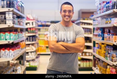 Positiver Mann im Lebensmittelgeschäft Stockfoto