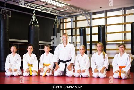 Kinder mit einem männlichen Lehrer, der in der Karate-Klasse posiert Stockfoto